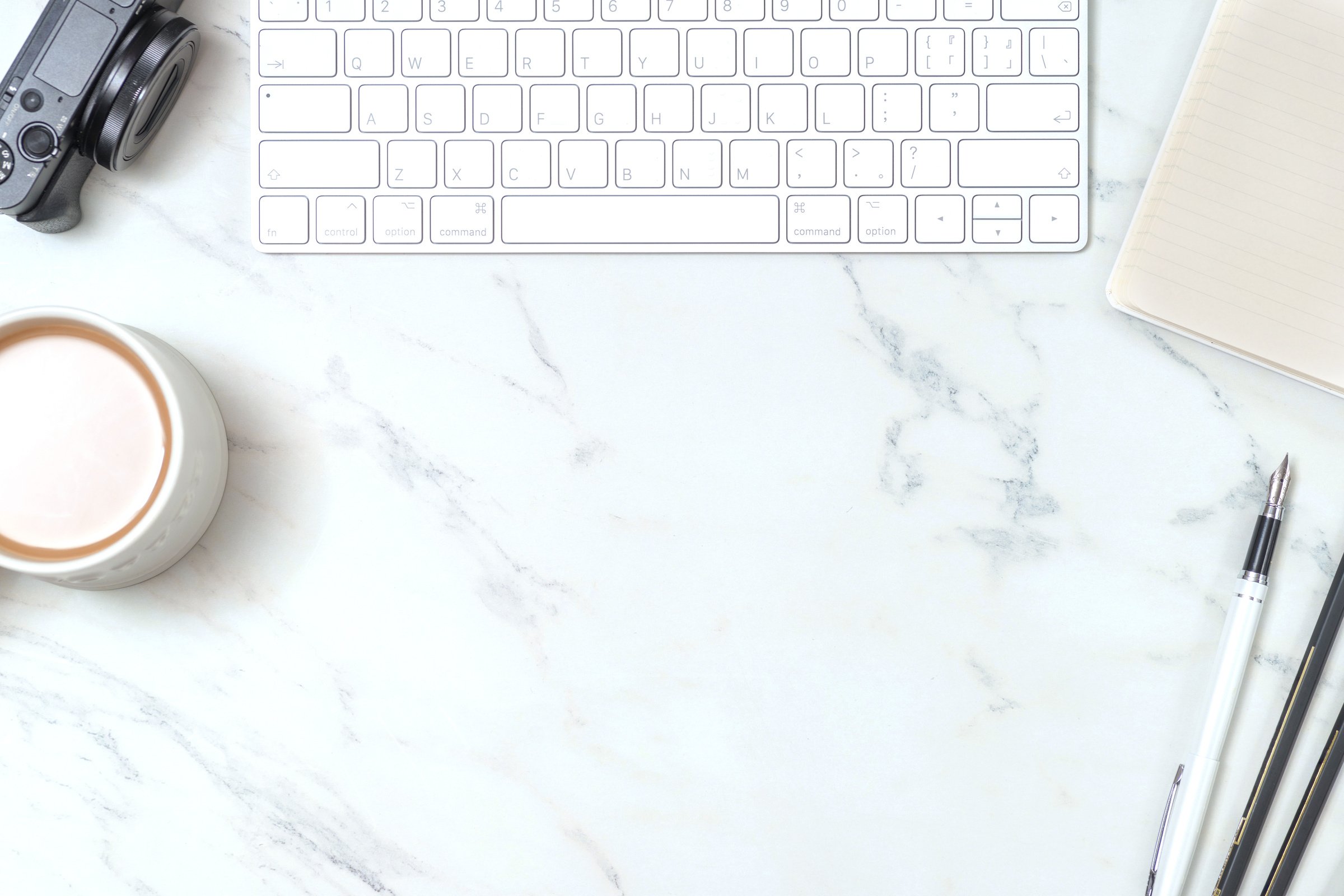 Marble study desk with keyboard, pen tablet, coffee and camera